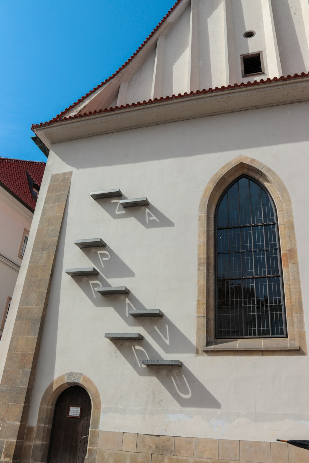 un edificio blanco con una gran ventana y un letrero en el costado