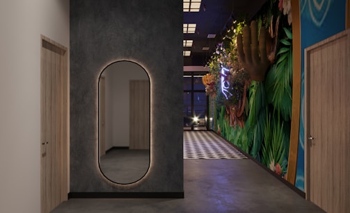 A spacious hallway with a tall floor mirror reflecting light.