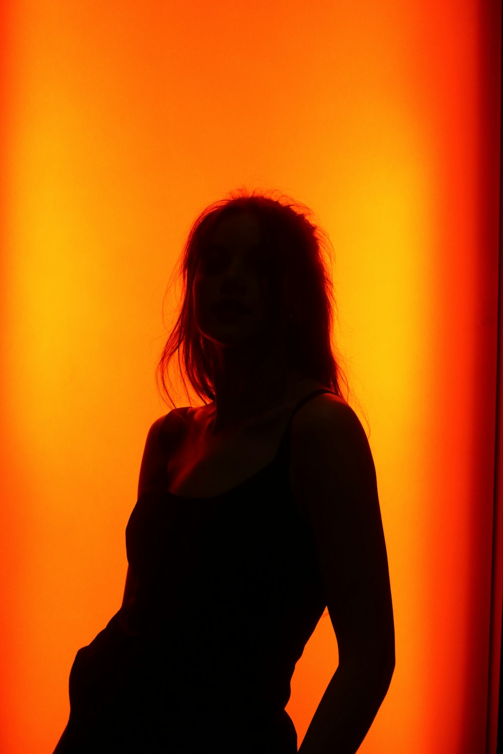 a pregnant woman standing in front of a red wall