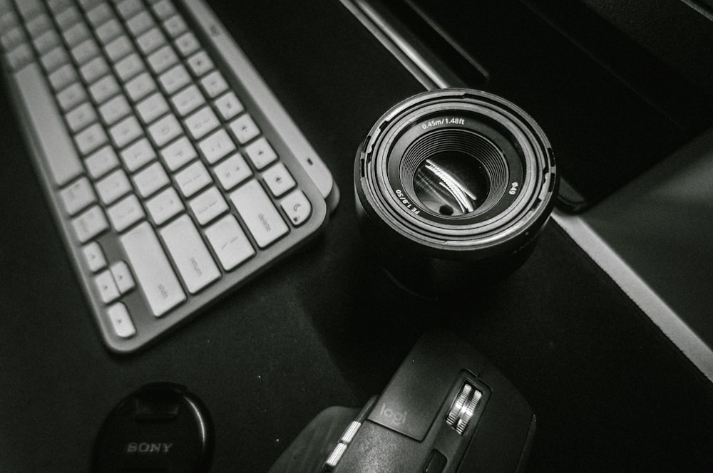 a black and white photo of a camera and a keyboard