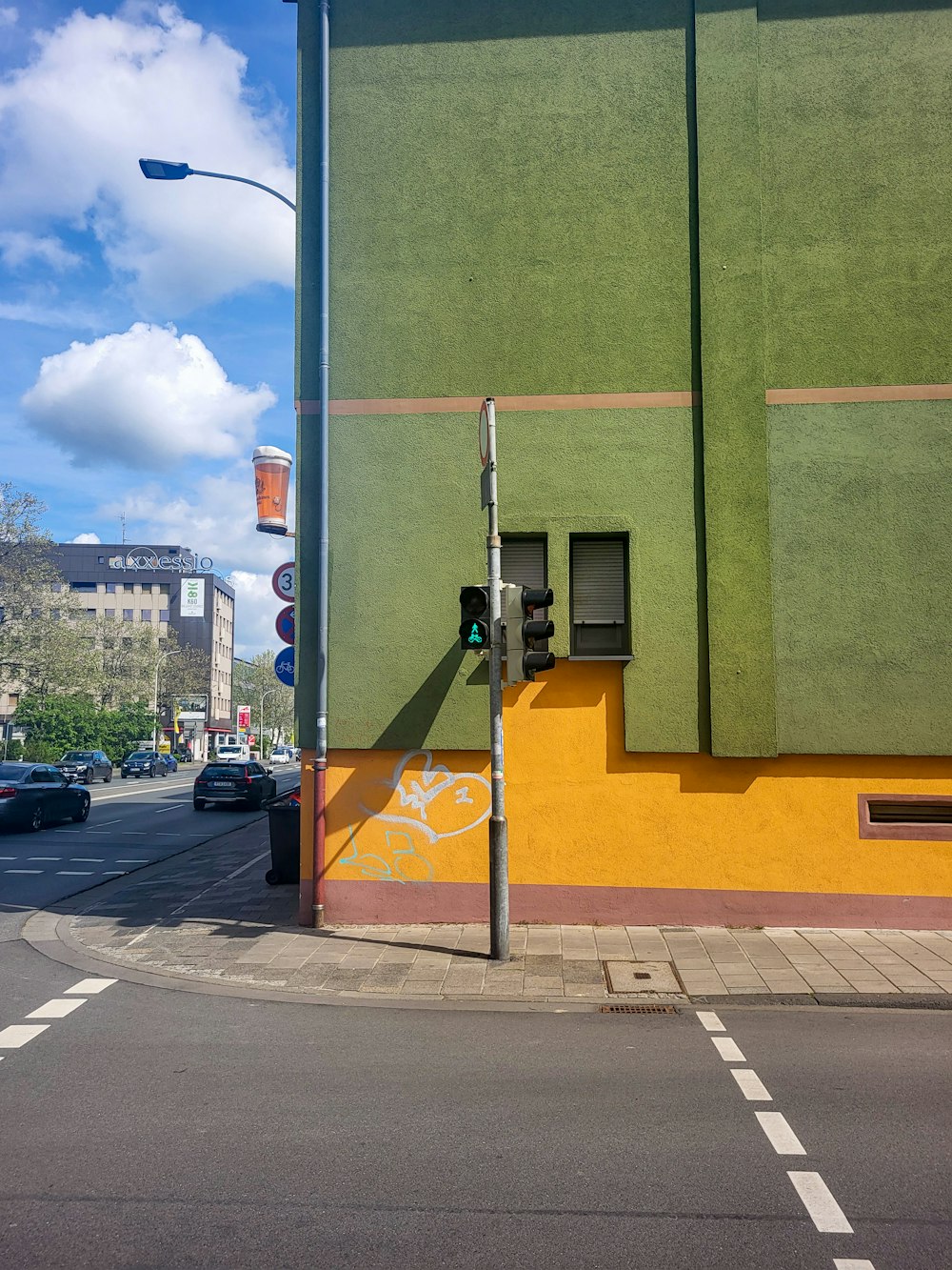 a street corner with a green building and a street light