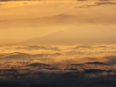 A crisp sunrise over Idaho’s rolling hills, sun rays piercing through light mist.