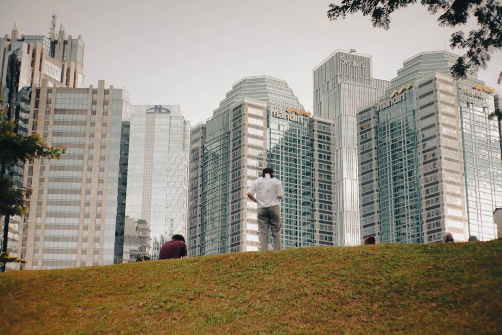 a man standing on top of a lush green hillside