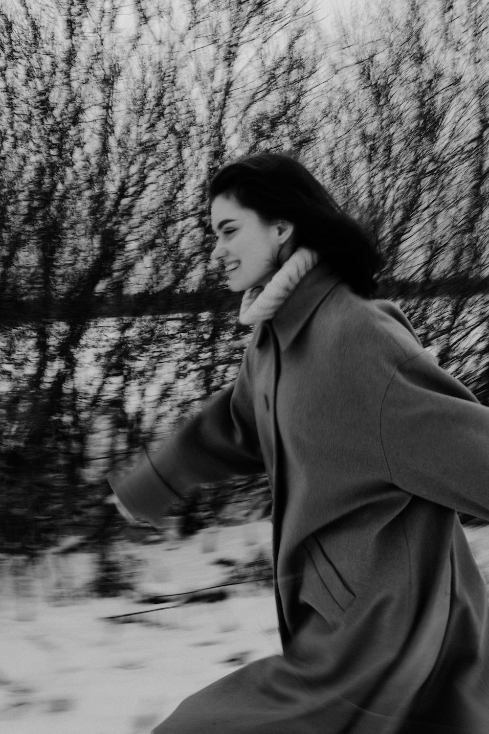 a woman in a coat is running in the snow