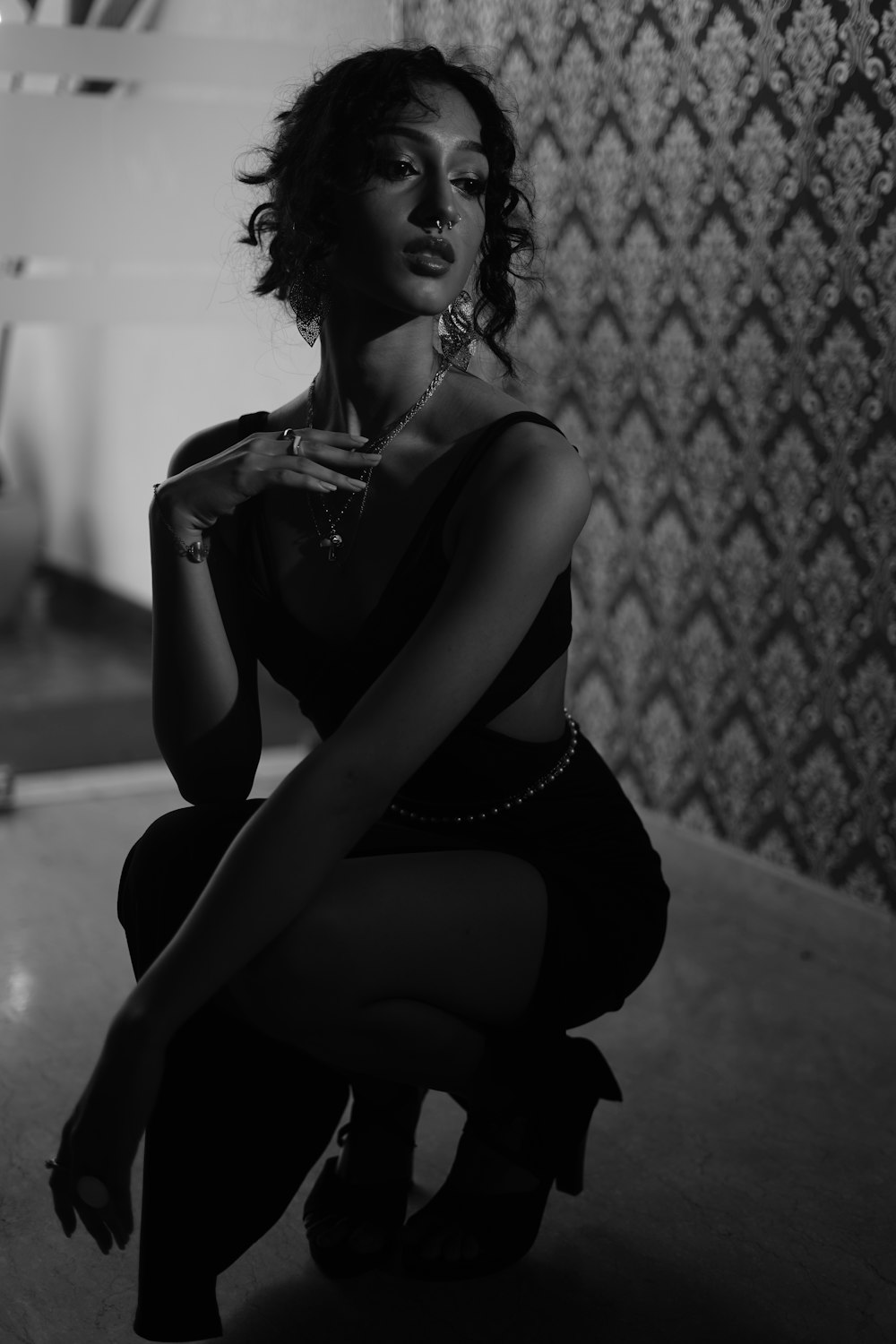 a black and white photo of a woman sitting on the floor