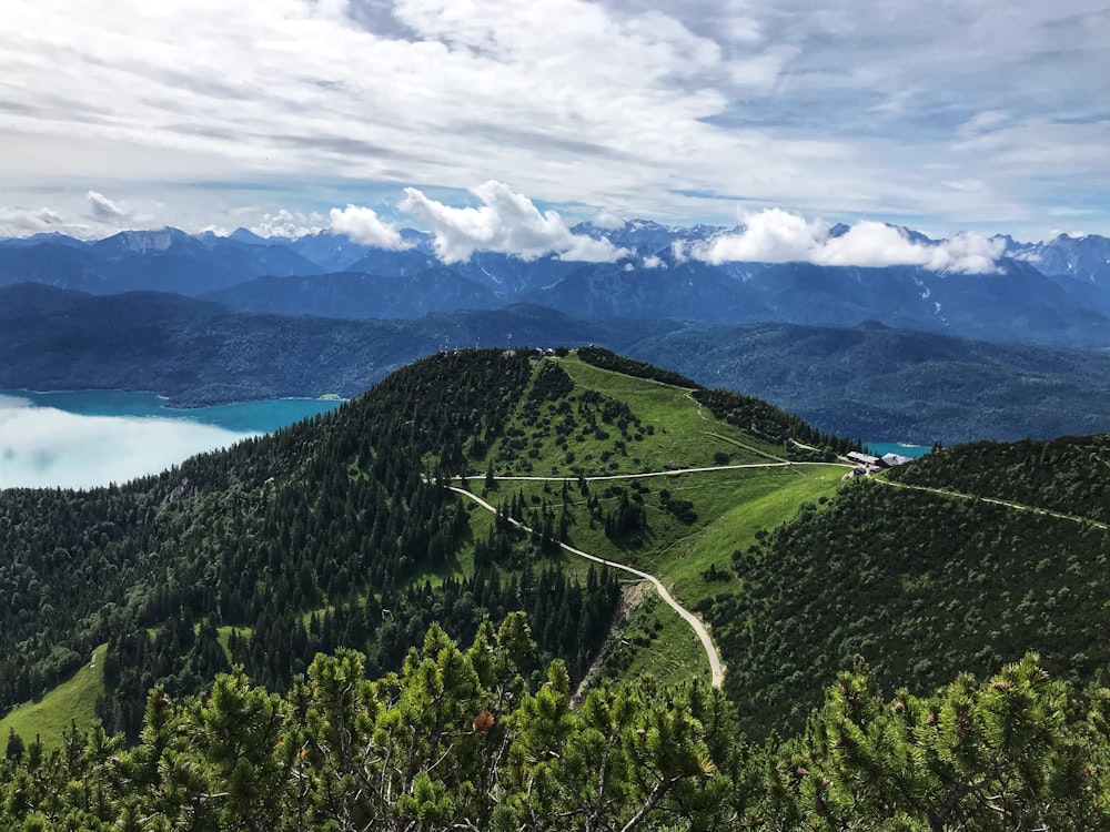 a scenic view of a mountain range with a lake in the distance