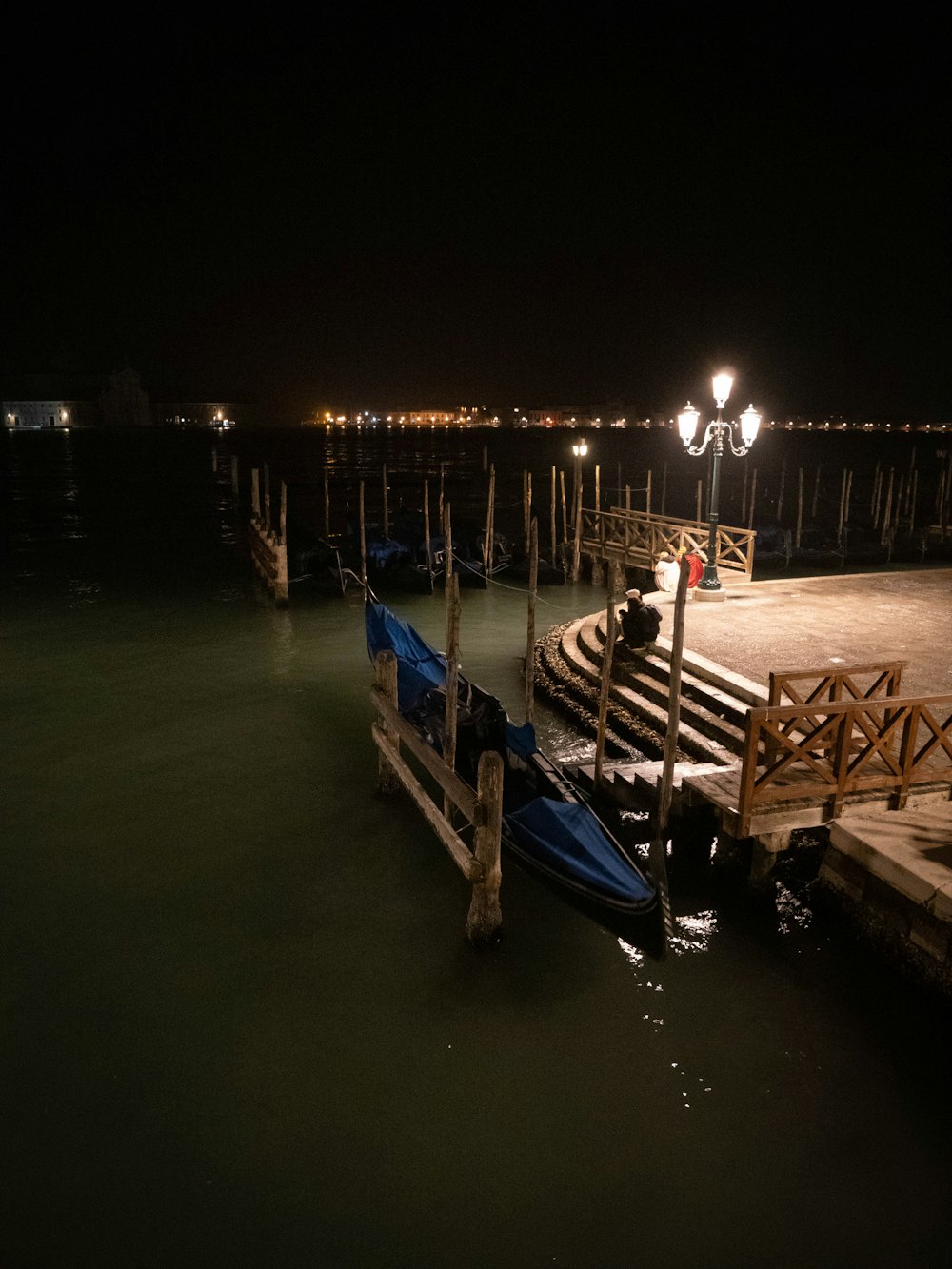 a dock at night with a row of boats in the water