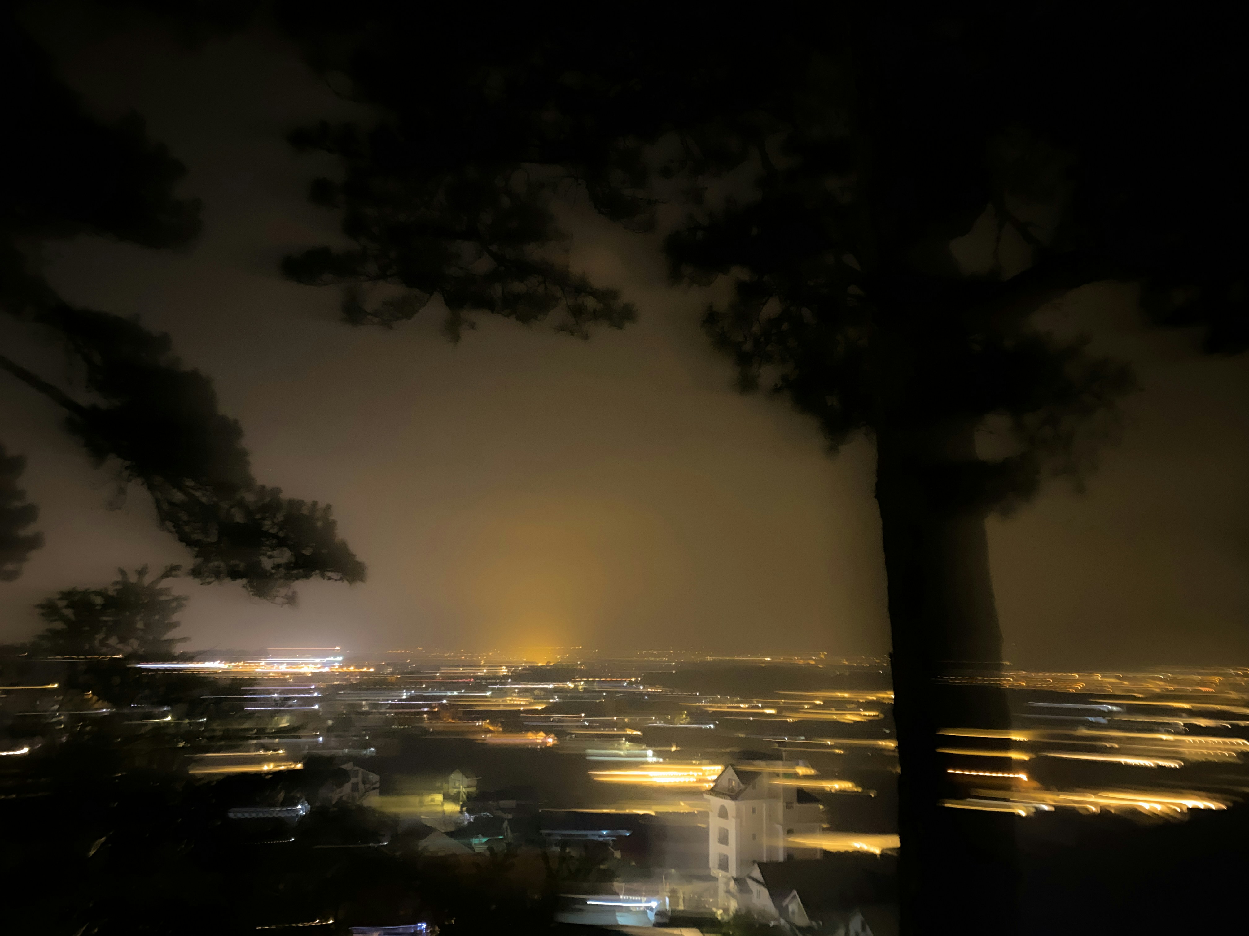 a view of a city at night from the top of a hill