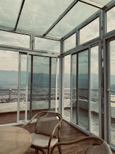 a chair and table in a room with large windows