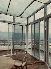 a chair and table in a room with large windows