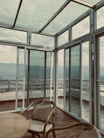 a chair and table in a room with large windows