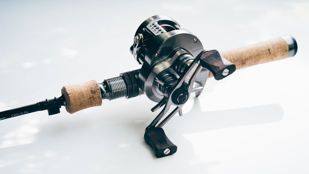 a fishing rod and reel on a white surface