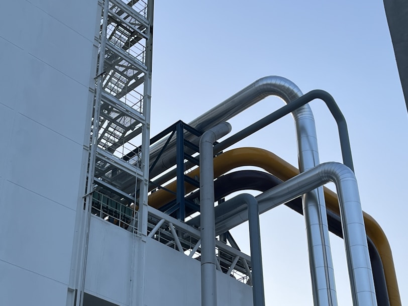 a large metal pipe next to a tall white building