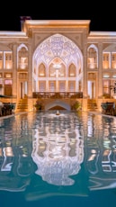 a large building with a pool in front of it