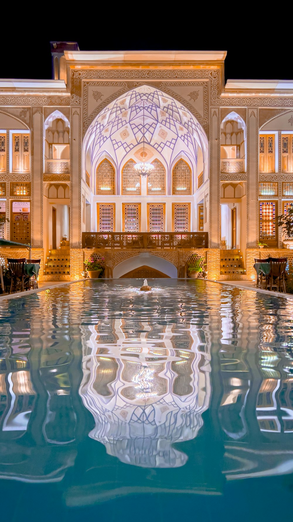 un grand bâtiment avec une piscine en face