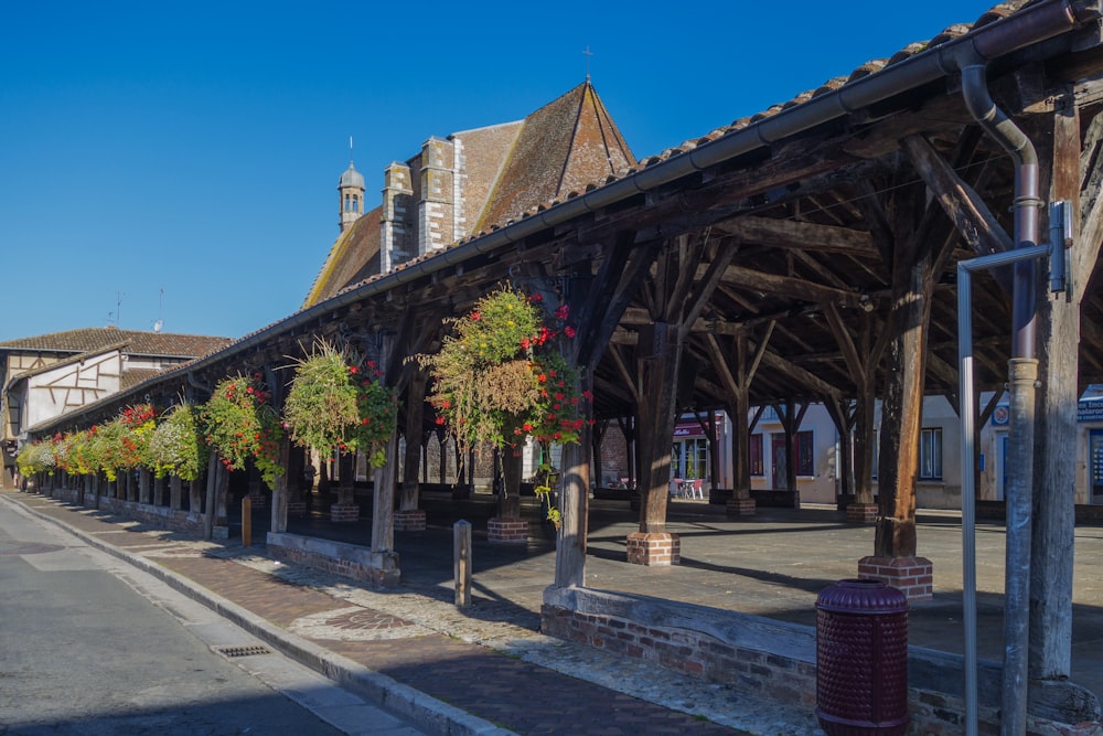 a wooden building with a bunch of flowers growing on it