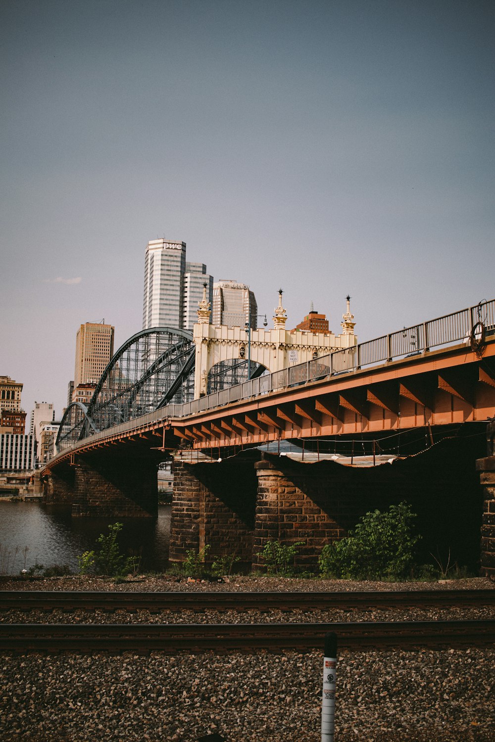 a bridge over a river with a city in the background