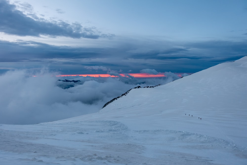 a group of people hiking up a snow covered mountain