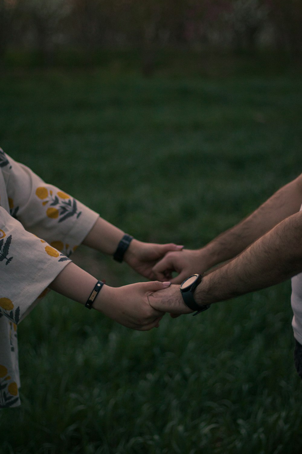 a man and a woman holding hands in the grass