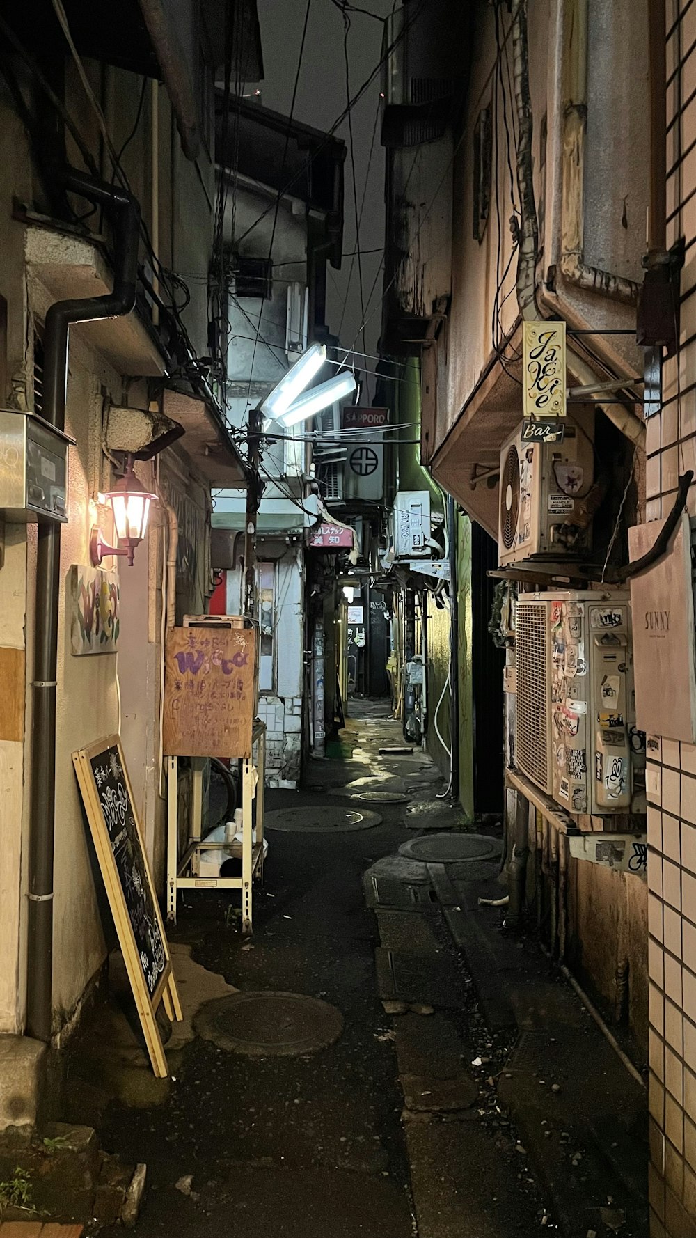 a narrow alley way with signs on the walls