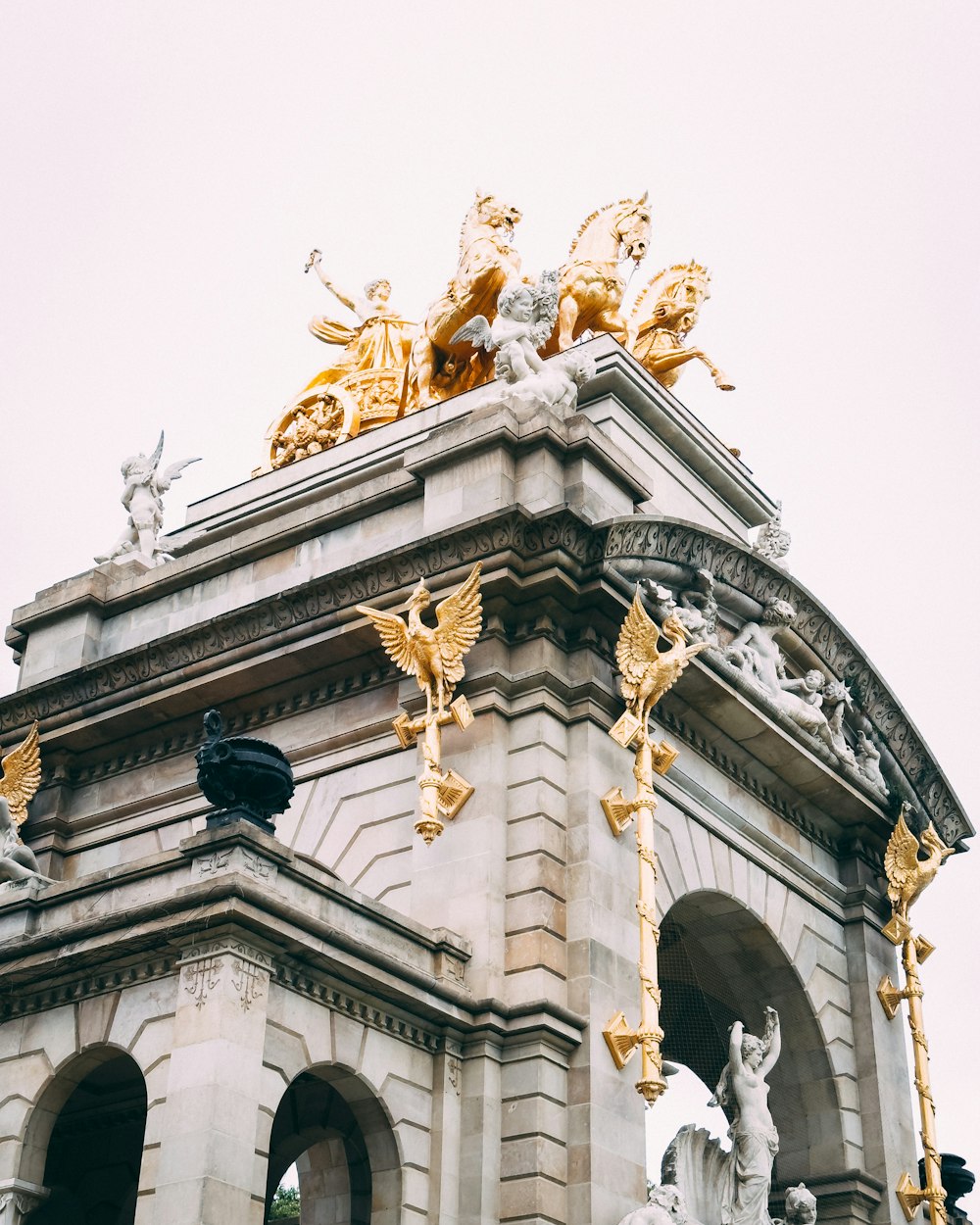 a clock tower with statues on top of it