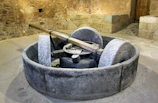 Traditional stone mill grinding olives in a rustic spanish olive mill.