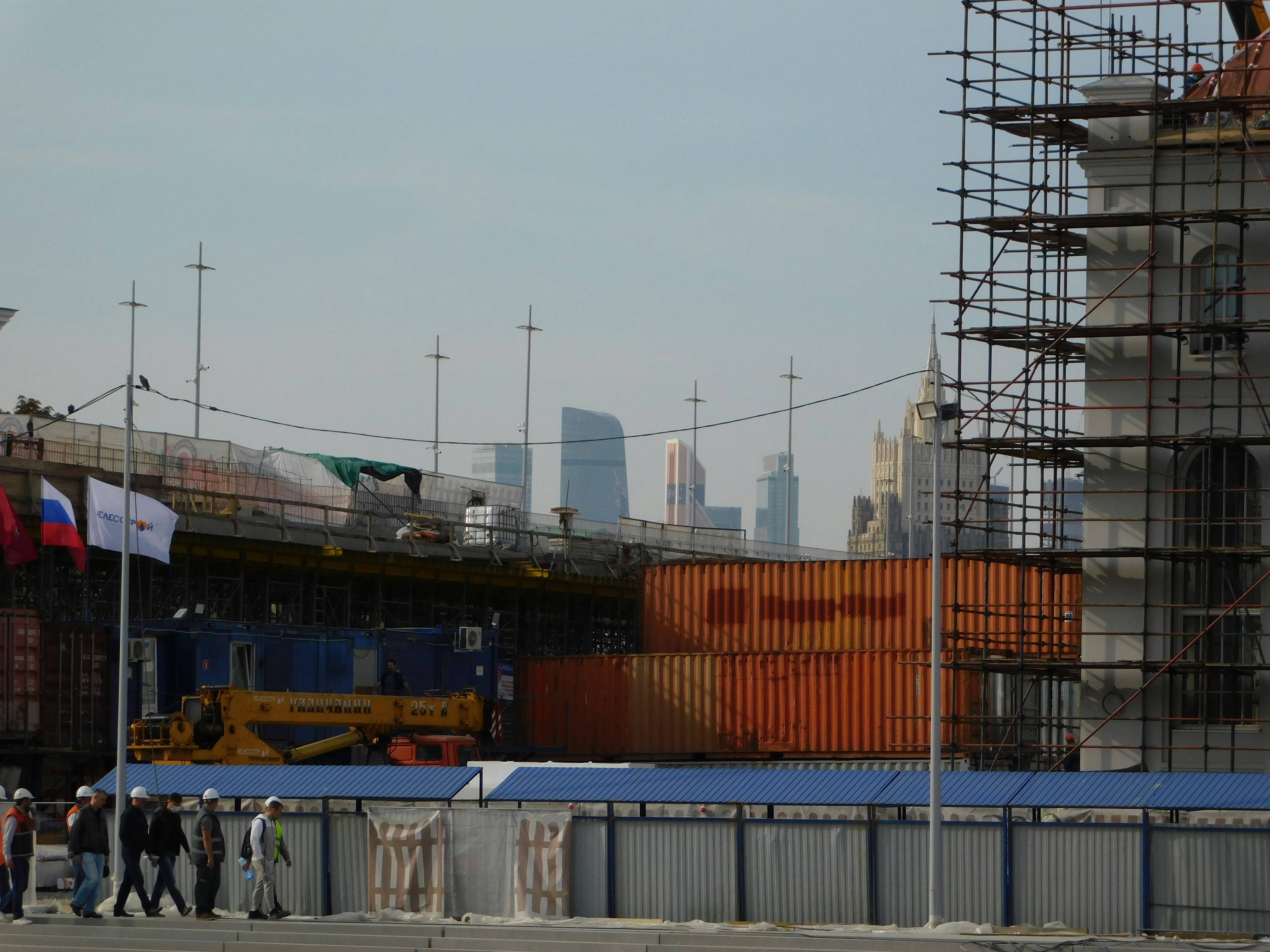 a group of people standing in front of a building under construction