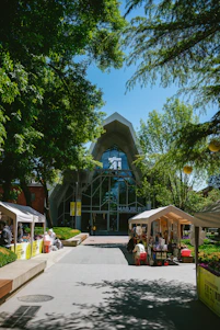 A bright, modern school building with students engaged in various activities outdoors.