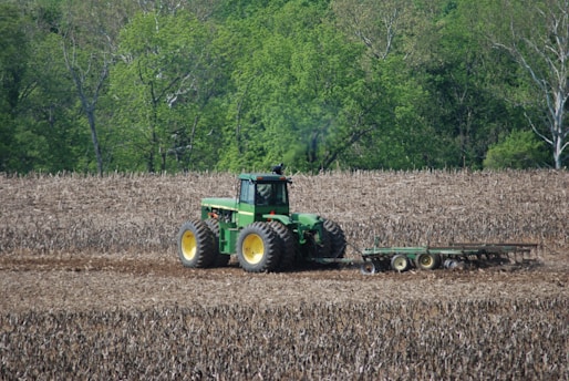 A modern tractor working in a green agricultural field during daylight