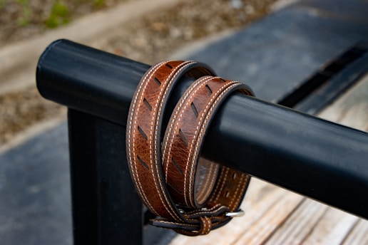 a close up of a leather belt on a bench