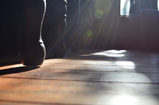 Natural light filtering through studio windows onto a poised dancer’s silhouette.