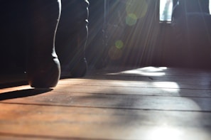 Close-up of a dancer’s feet gracefully moving on a wooden floor with natural light.