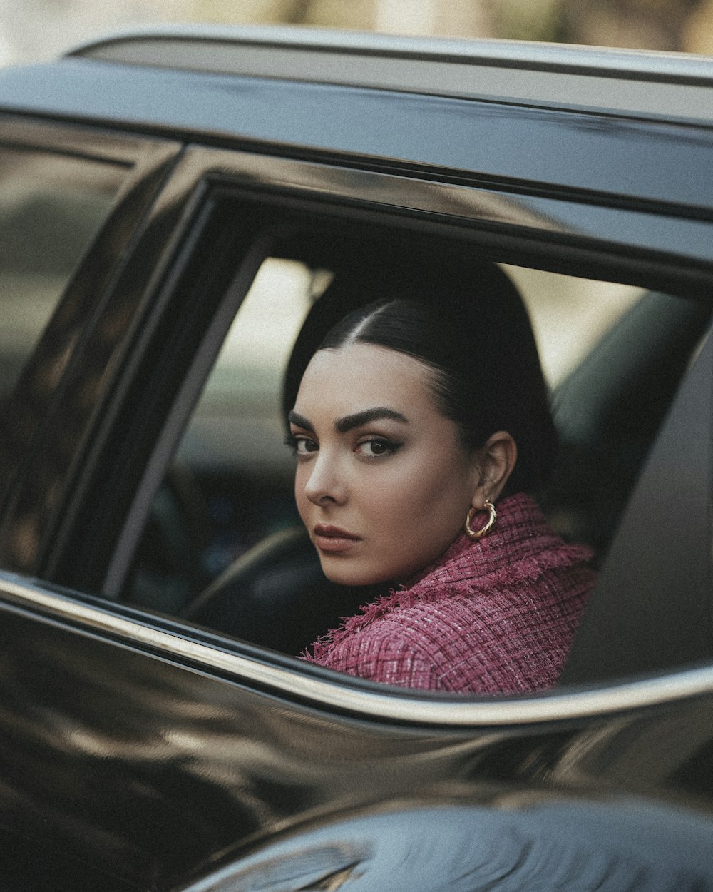 a woman sitting in a car looking out the window