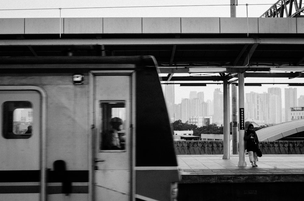 a person standing on a platform next to a train