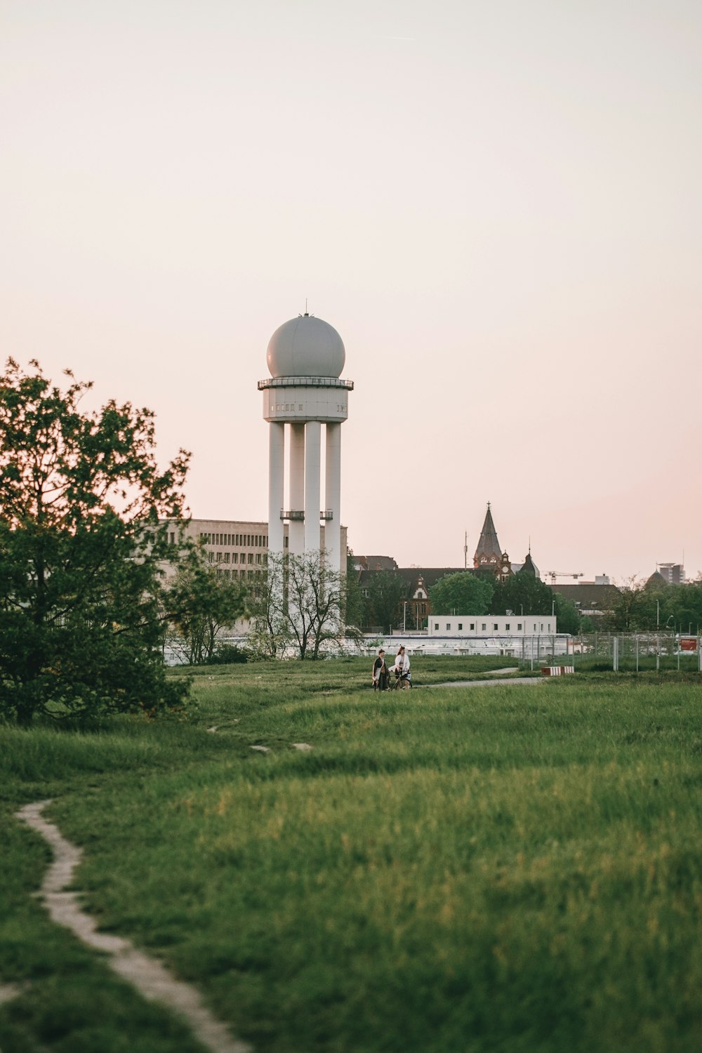 a grassy field with a water tower in the background