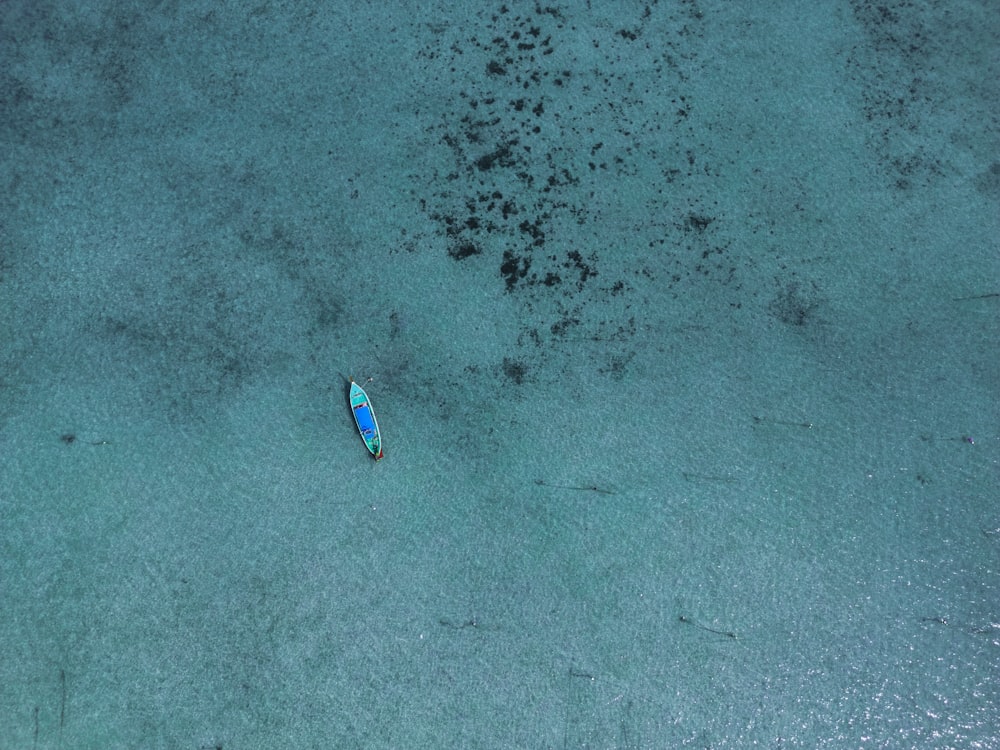 an aerial view of a small boat in the water