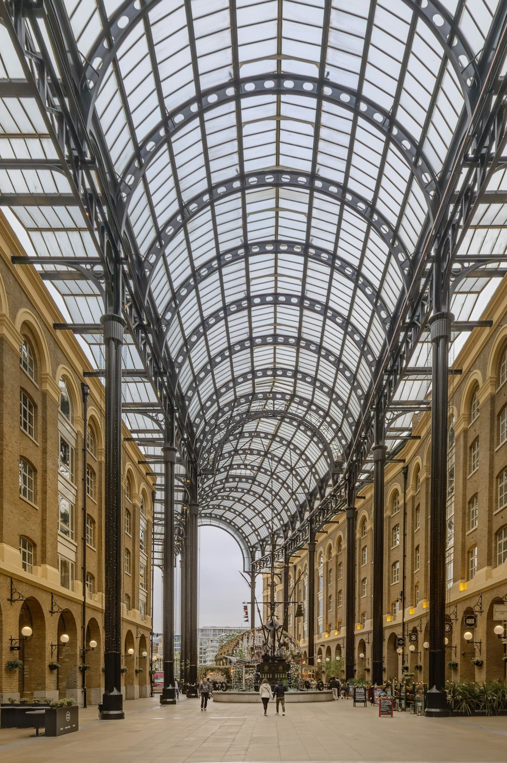 a couple of people walking down a walkway in a building