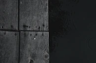 Close-up of rustic wooden dock posts against gently rippling harbor waters.