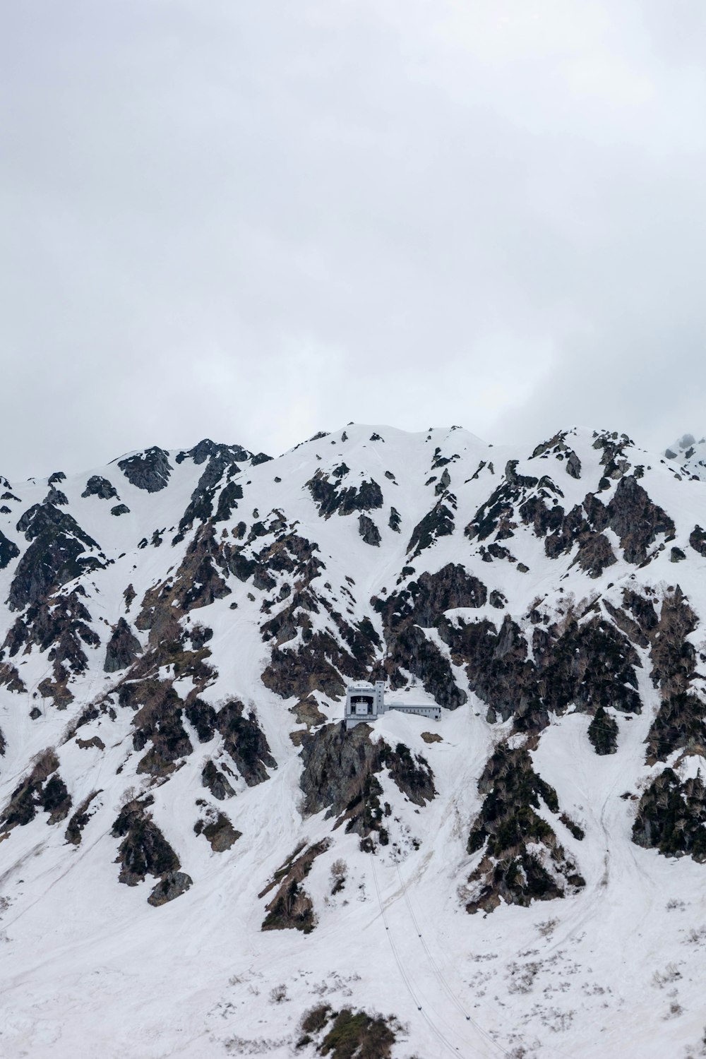 a mountain covered in snow with a sky background