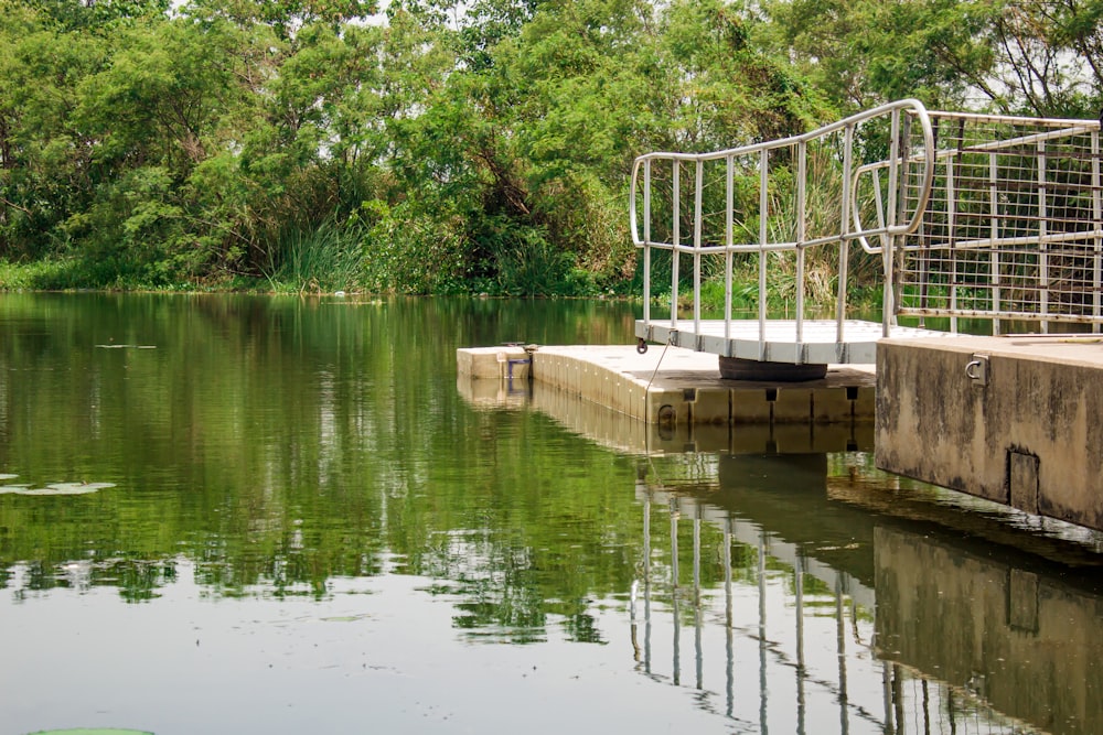 a metal cage sitting on the edge of a body of water