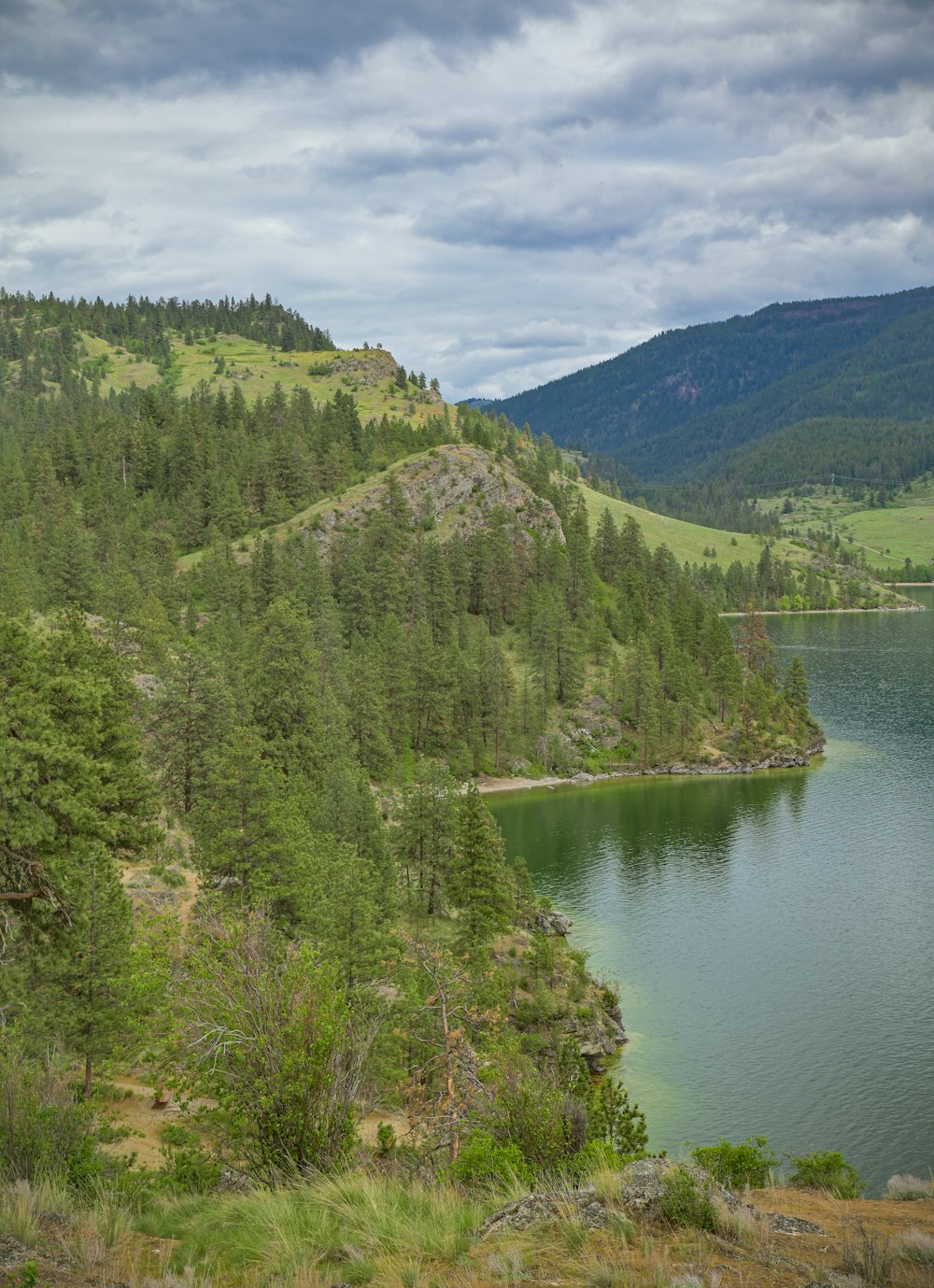 a large body of water surrounded by a lush green hillside