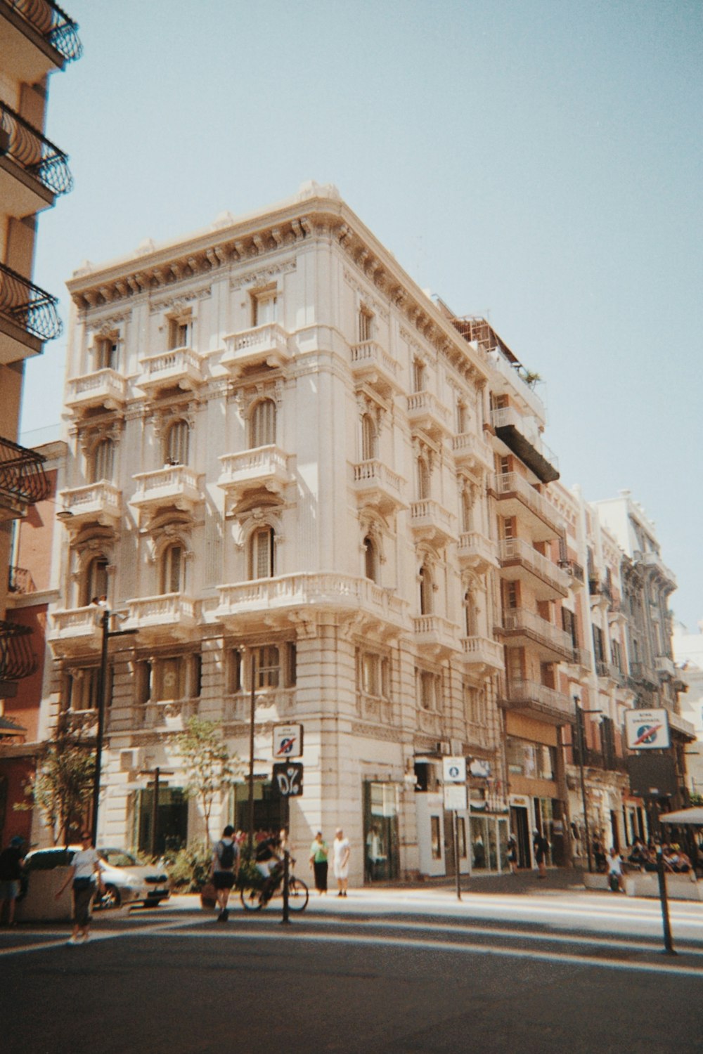 ein großes weißes Gebäude, das am Straßenrand sitzt