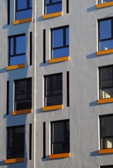 Modern aluminium window frames installed on a bright residential building facade.