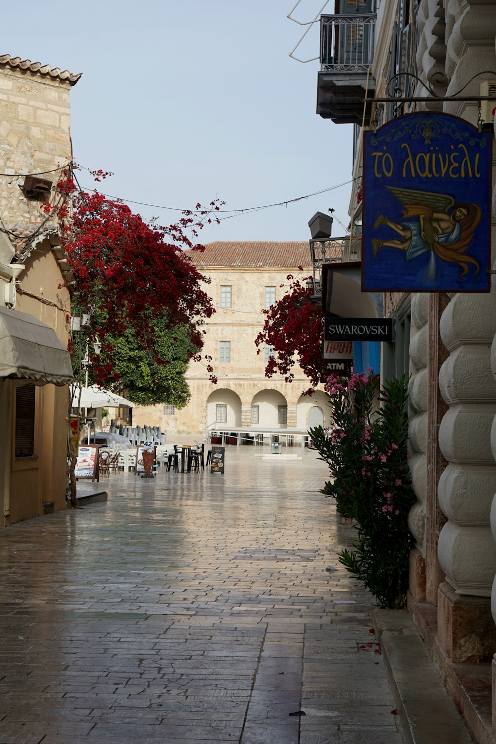 Una strada di ciottoli fiancheggiata da negozi e fiori