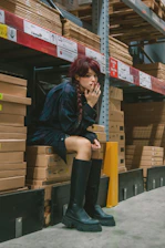 a woman sitting on a pallet in a warehouse