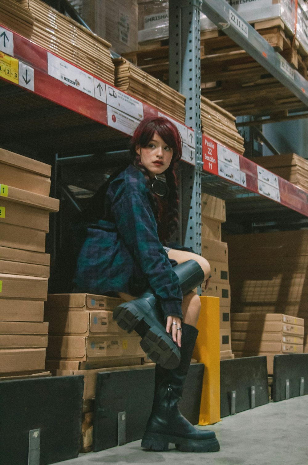 a woman sitting on a pallet in a warehouse
