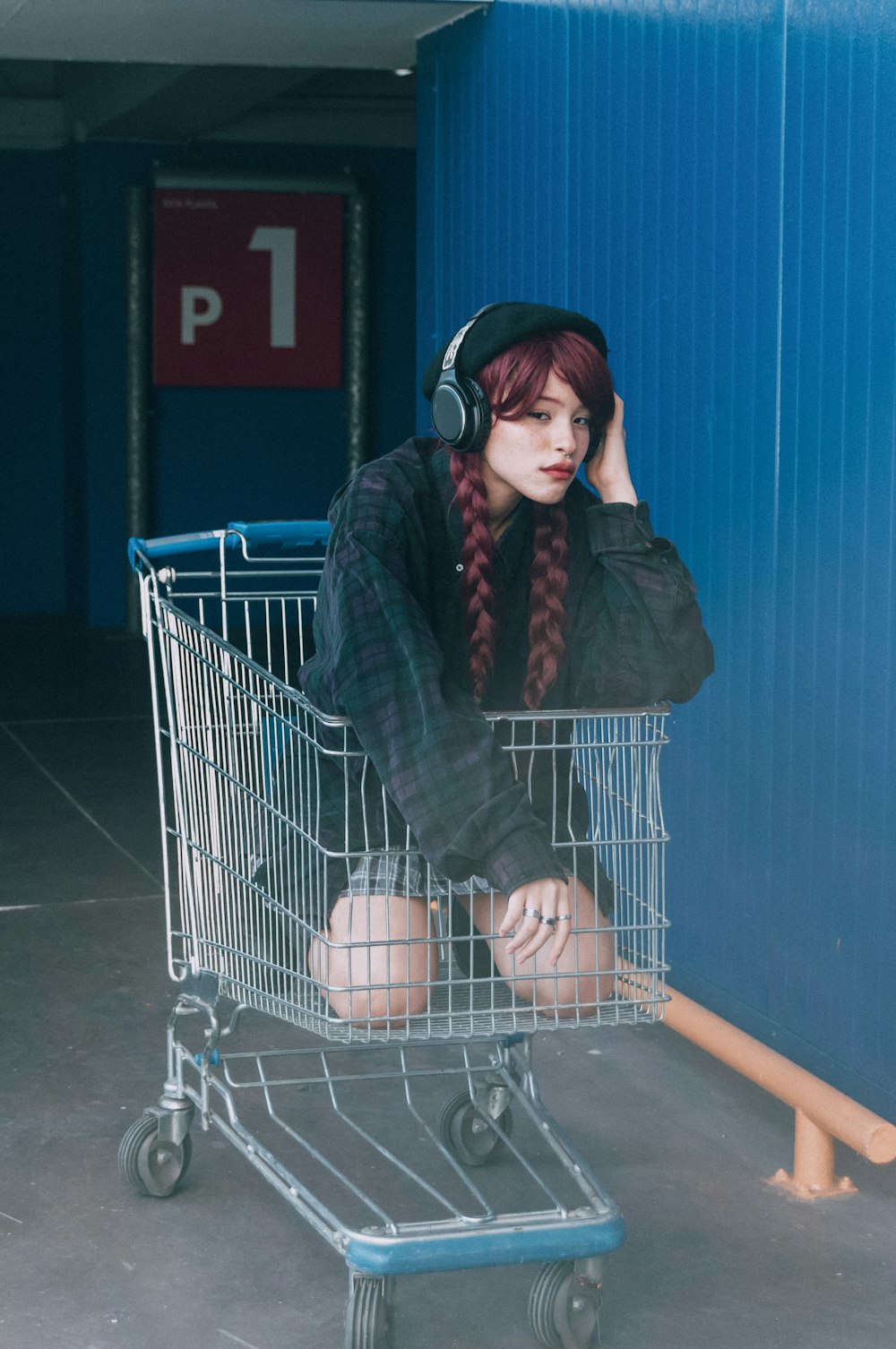 a woman sitting in a shopping cart with headphones on