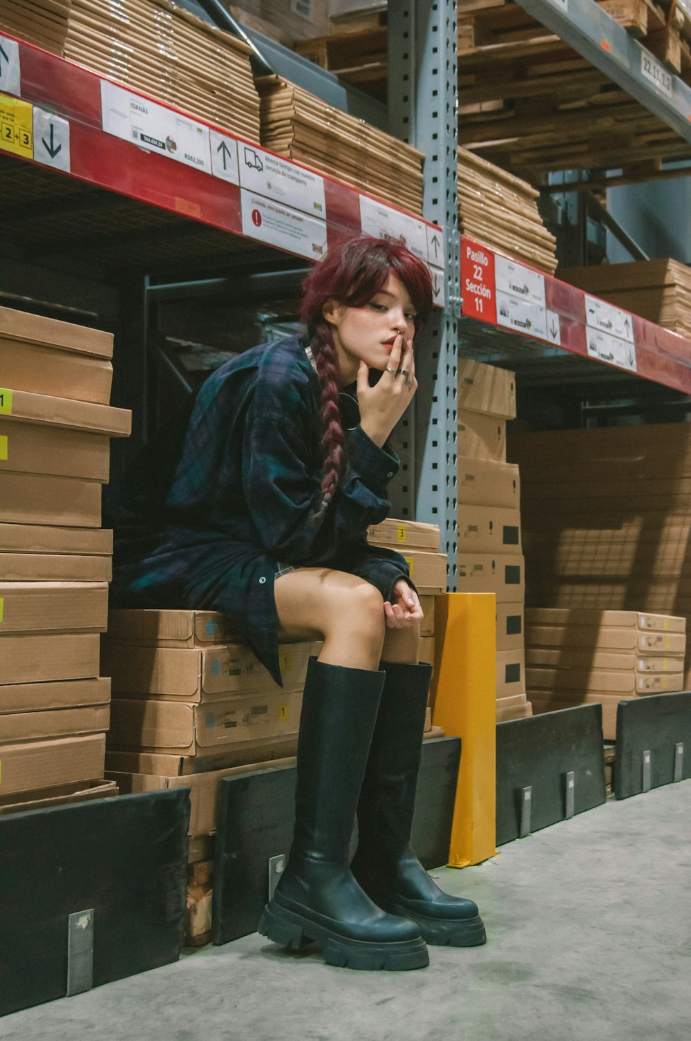 a woman sitting on a pallet in a warehouse