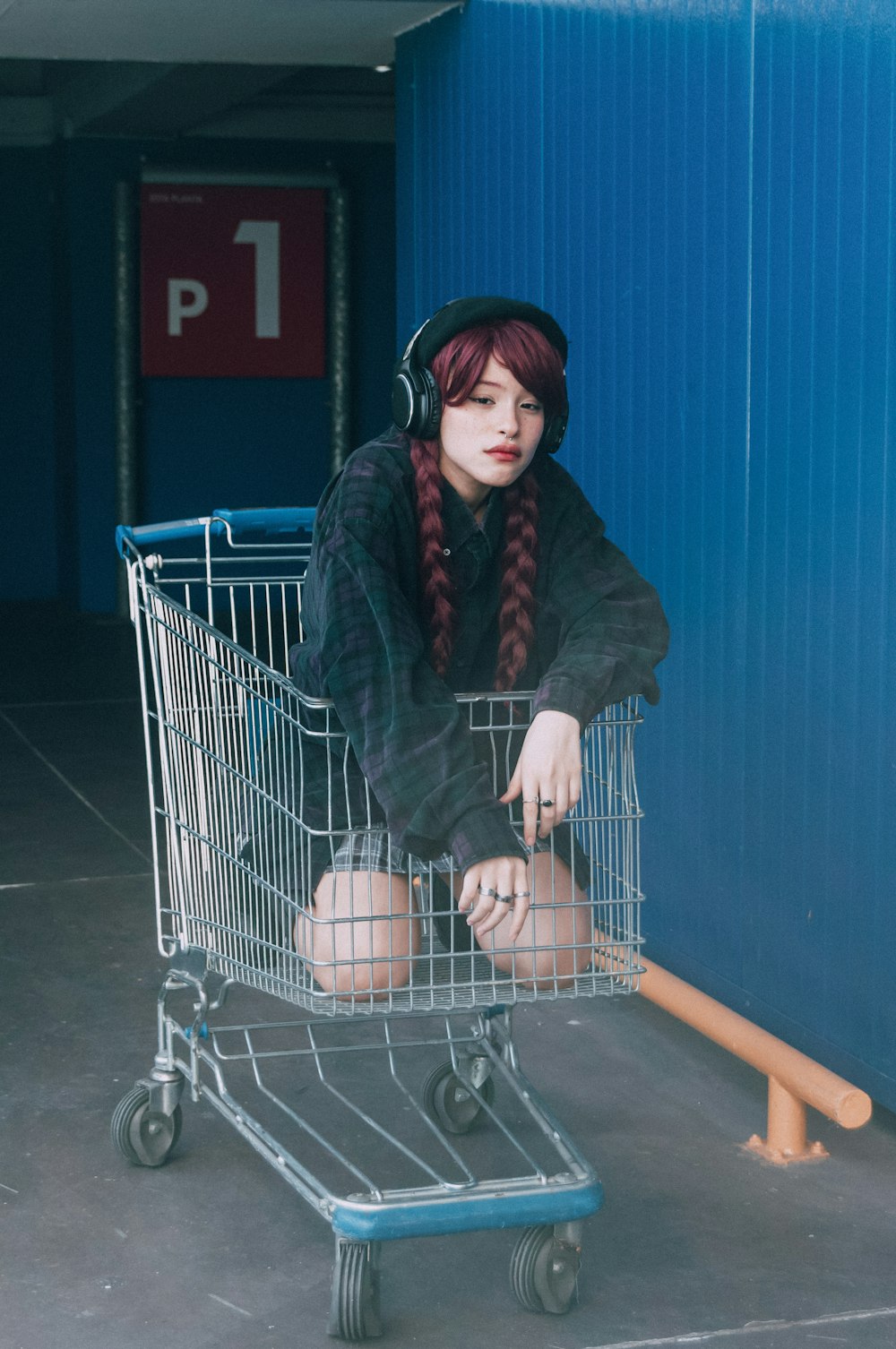 a woman with red hair sitting in a shopping cart