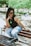 a woman sitting on top of a wooden bench